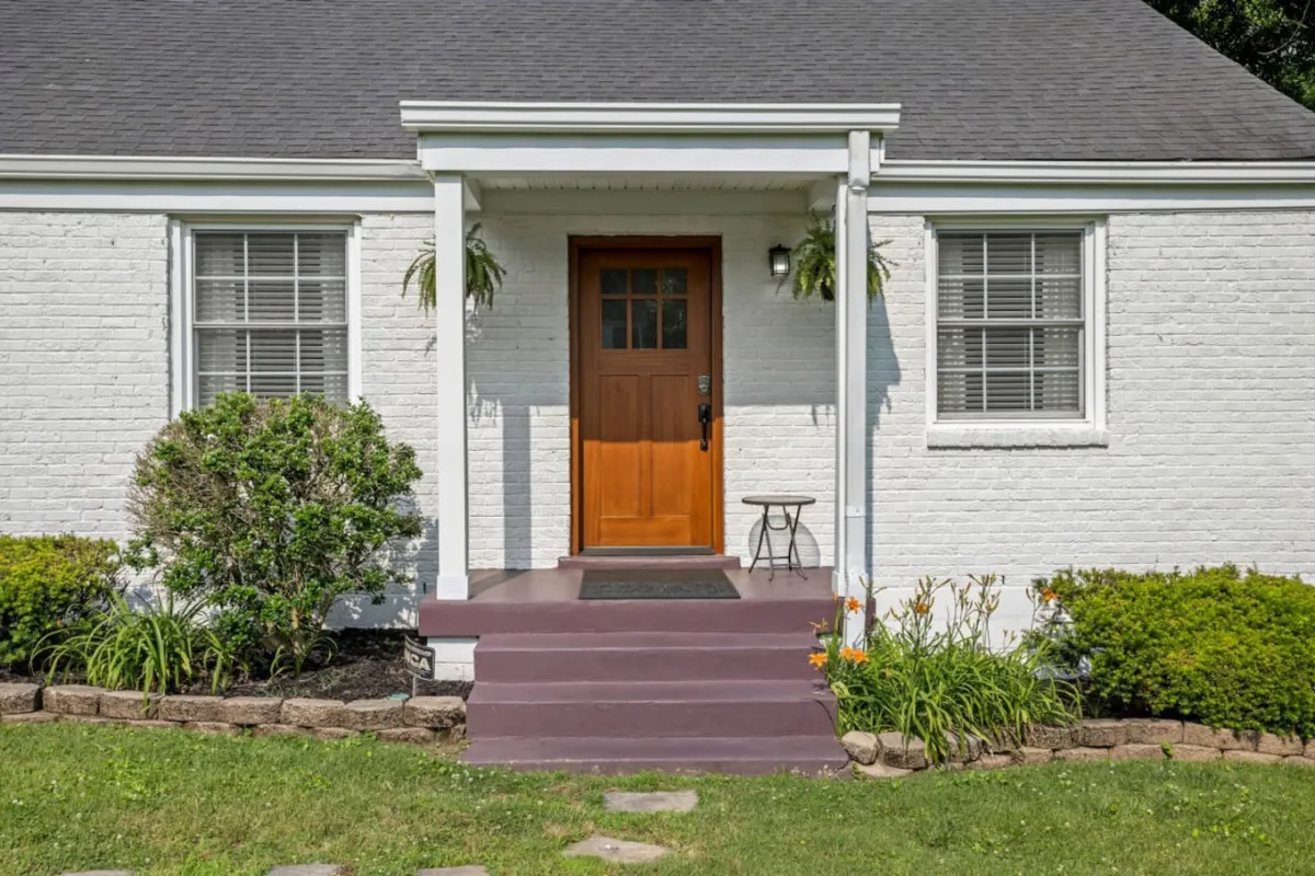 A welcoming exterior view of the home, featuring the front door, steps, and well-maintained landscaping. The inviting porch provides a glimpse of a space perfect for relaxing or gathering, with ample room for family members to enjoy the outdoors.