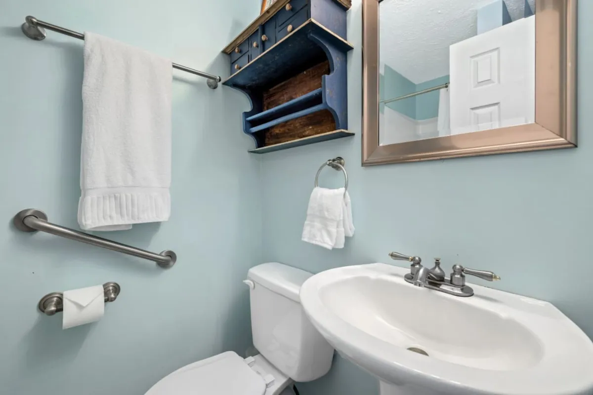 This inviting bathroom features a clean sink, mirror, blue shelving, and fresh towels, creating a serene space for personal grooming and refreshment. The mood is calming and welcoming, suggesting a convenient spot to prepare for a night out or unwind after an evening in Inglewood.